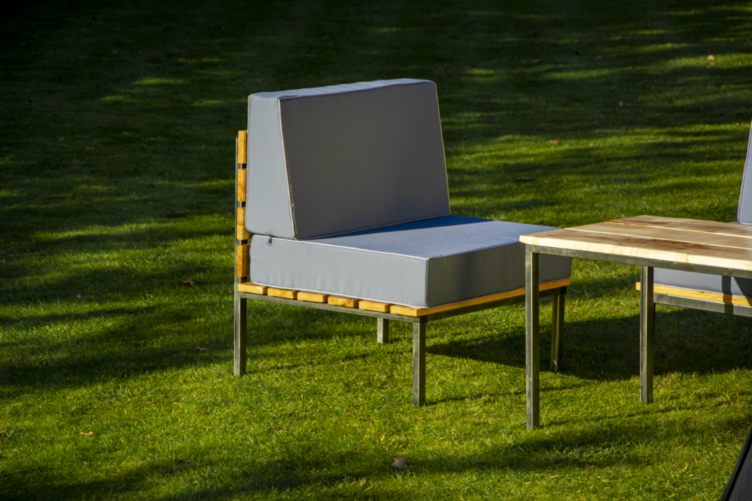Fotel ogrodowy Lazy z drewna dębowego i surowej stali, fotel w zestawie z materacami obitymi wodoodpornym materiałem. Fotel jest częścią zestawu mebli ogrodowych.